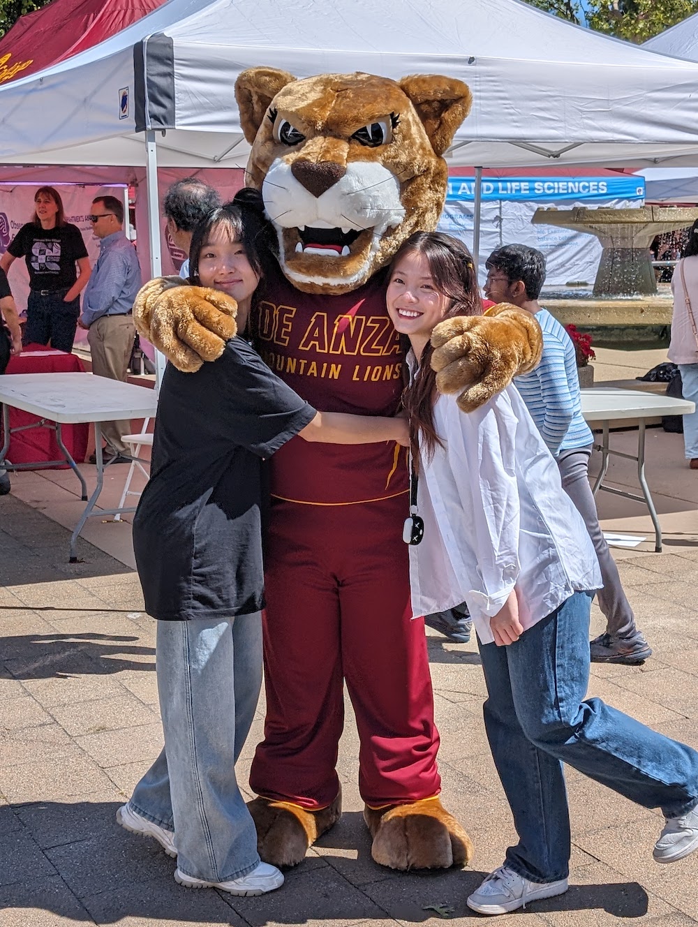 Roary gets a hug from two students in Main Quad