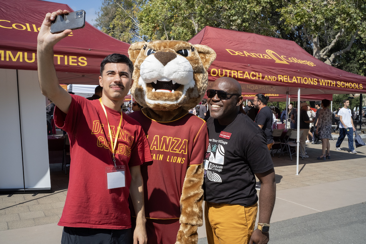 Roary posing for selfie with staffer and President Holmes