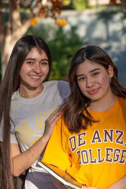 two students, one with yellow de anza jersey and notebook