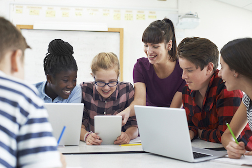 teacher with young students at table